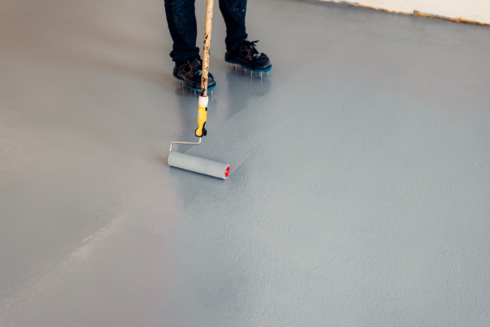 A,Construction,Worker,Apply,Grey,Epoxy,Resin,In,An,Industrial